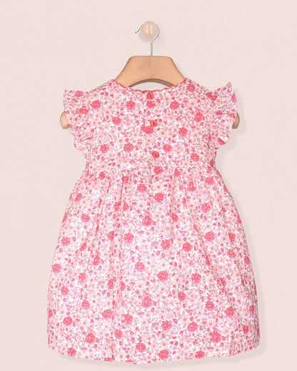 back of pink Floral dress on a hanger against a plain background