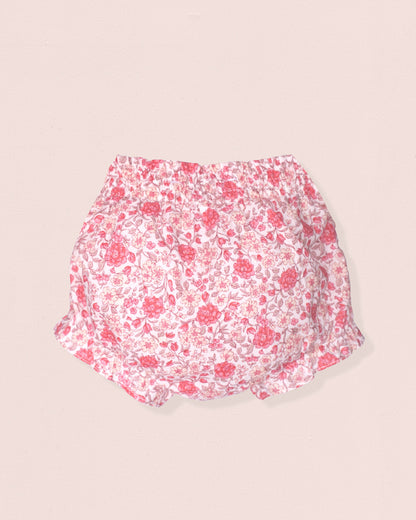 Floral-patterned baby bloomers on a beige background