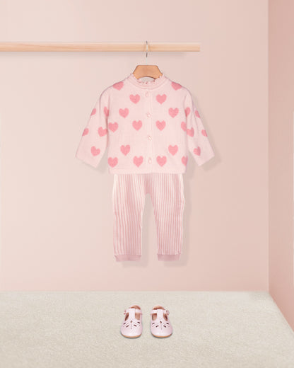 Children's outfit with heart pattern on a pink background