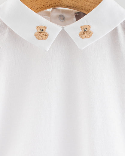 Close-up of the Andreas Baby Onesie’s collar, showing two beige teddy bear embroideries on each side of the pointed collar.