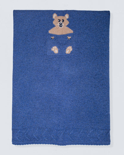 Blue knitted blanket with a bear design on a white background