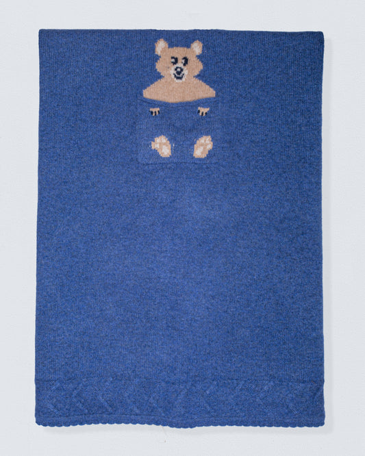 Blue knitted blanket with a bear design on a white background