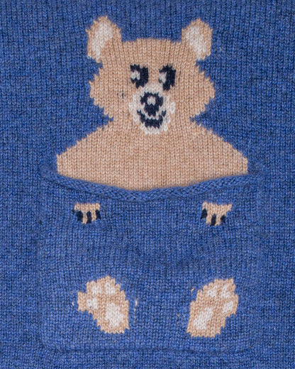 Close up image of a jean-blue cashmere sweater with a bear design.