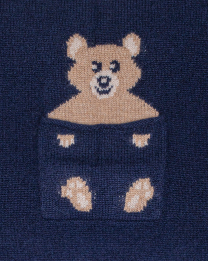Close-up of a navy blue sweater with a teddy bear design.