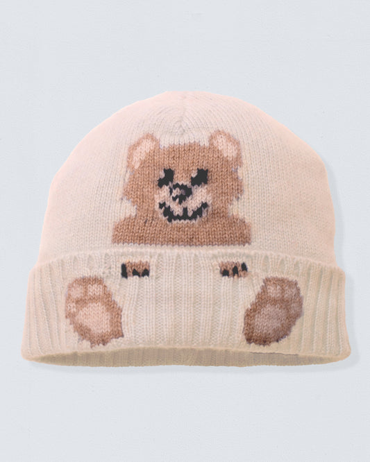 Knitted beige beanie with bear design on a light gray background