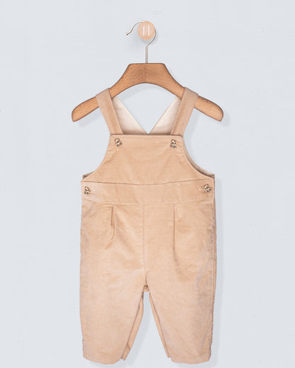 Beige overalls hanging on a wooden hanger against a light gray background