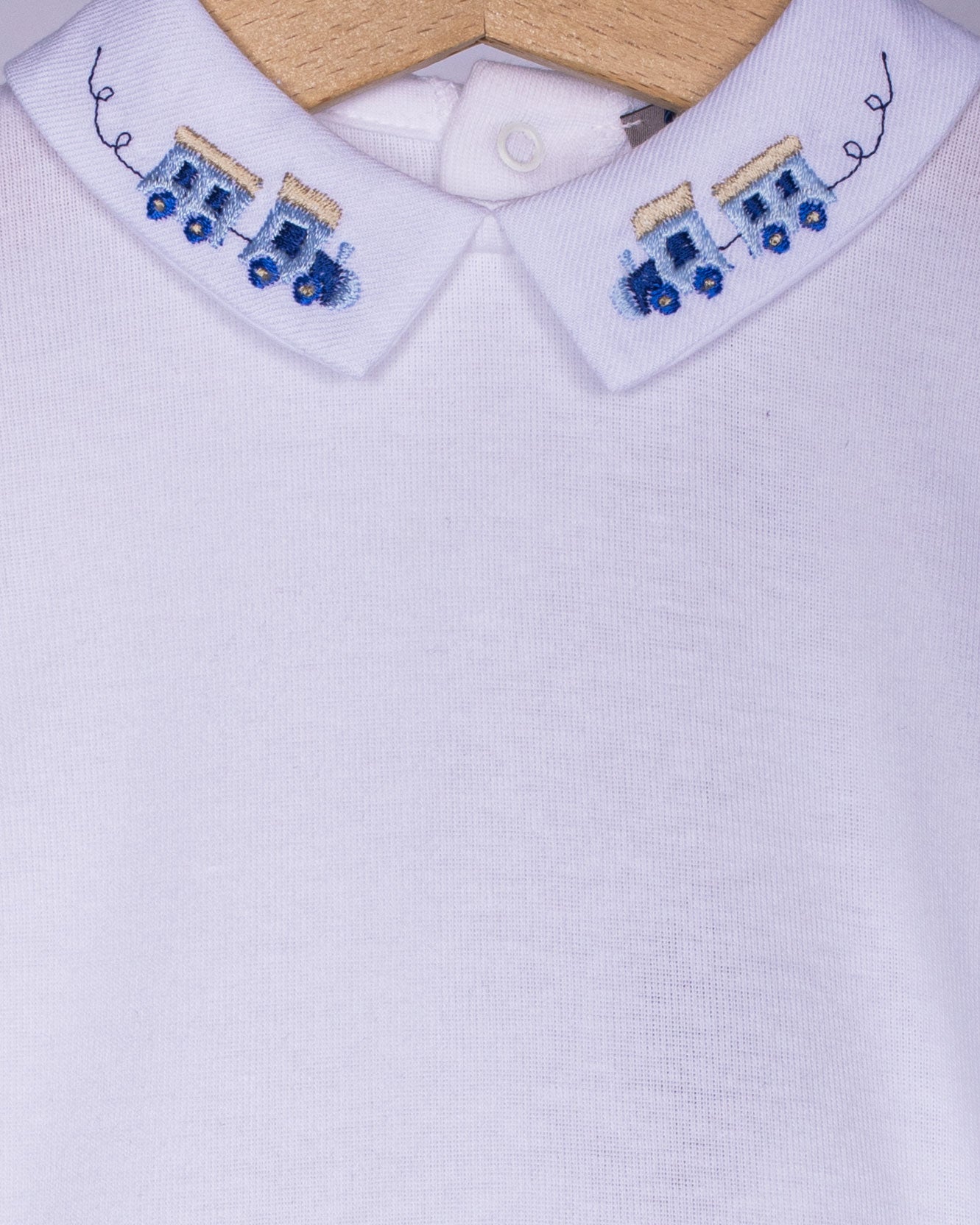 close-up White shirt collar with train embroidered blue designs on a white background
