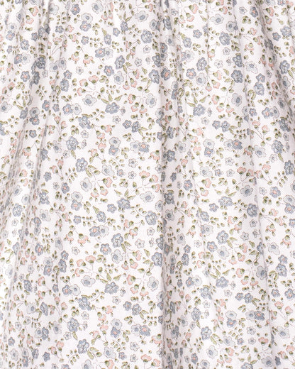 A close-up of the dress’s floral twill fabric, highlighting the fine print of blue, pink, and green flowers scattered across the white background.