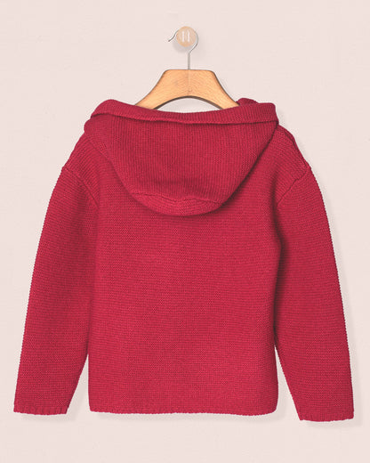 fuchia knitted sweater on a hanger against a light pink background