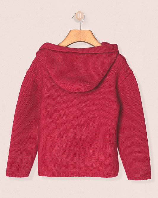 fuchia knitted sweater on a hanger against a light pink background