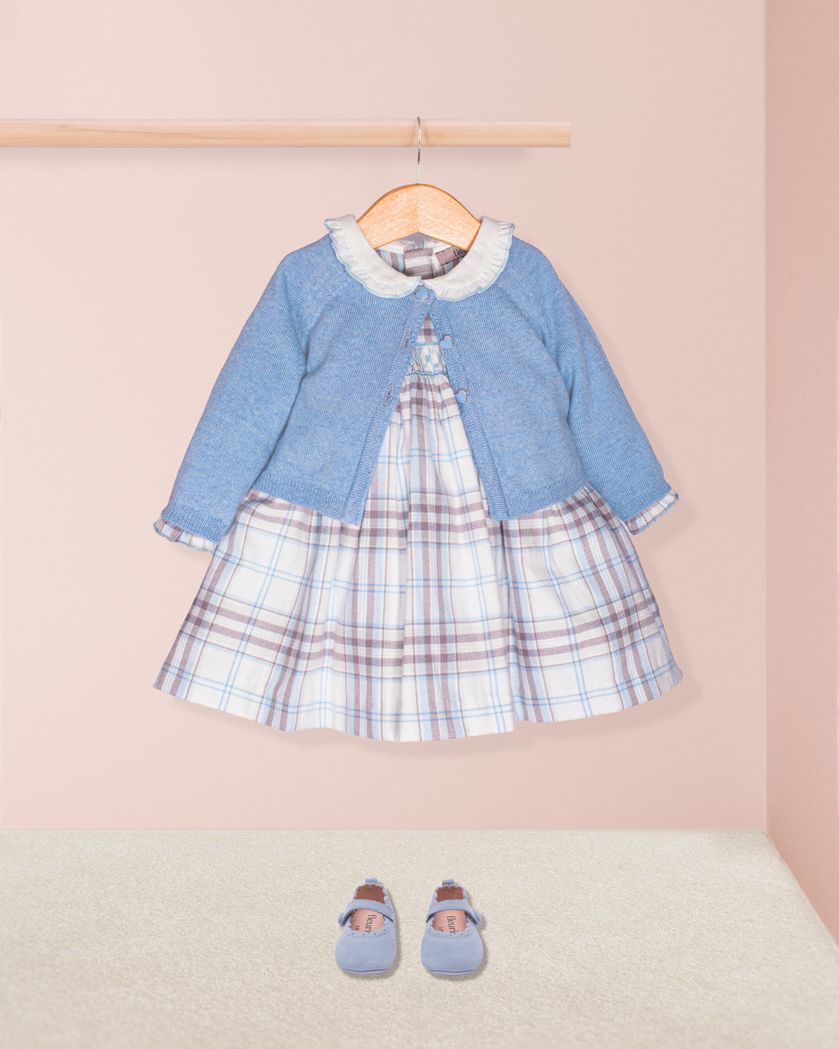 blue plaid dress on hanger with blue cardigan on pink backdrop with blue shoes