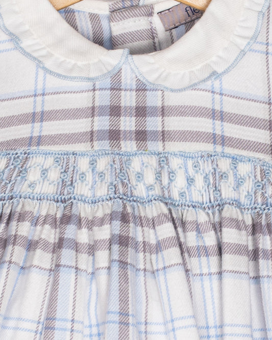 Close-up of a plaid dress with a visible brand label on a white background