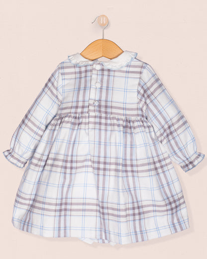 Plaid dress on a wooden hanger against a beige background