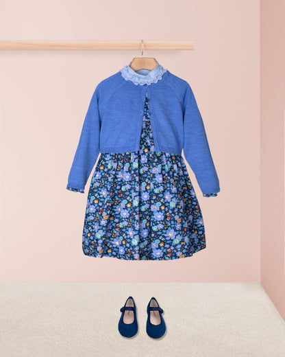 Blue dress with floral pattern and matching shoes on a pink background