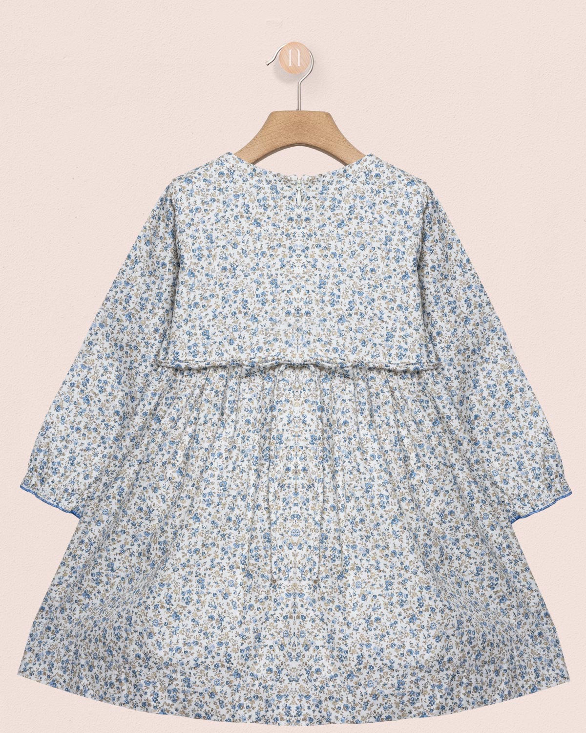 Floral dress on a hanger against a beige background