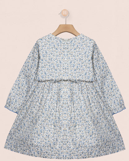 Floral dress on a hanger against a beige background