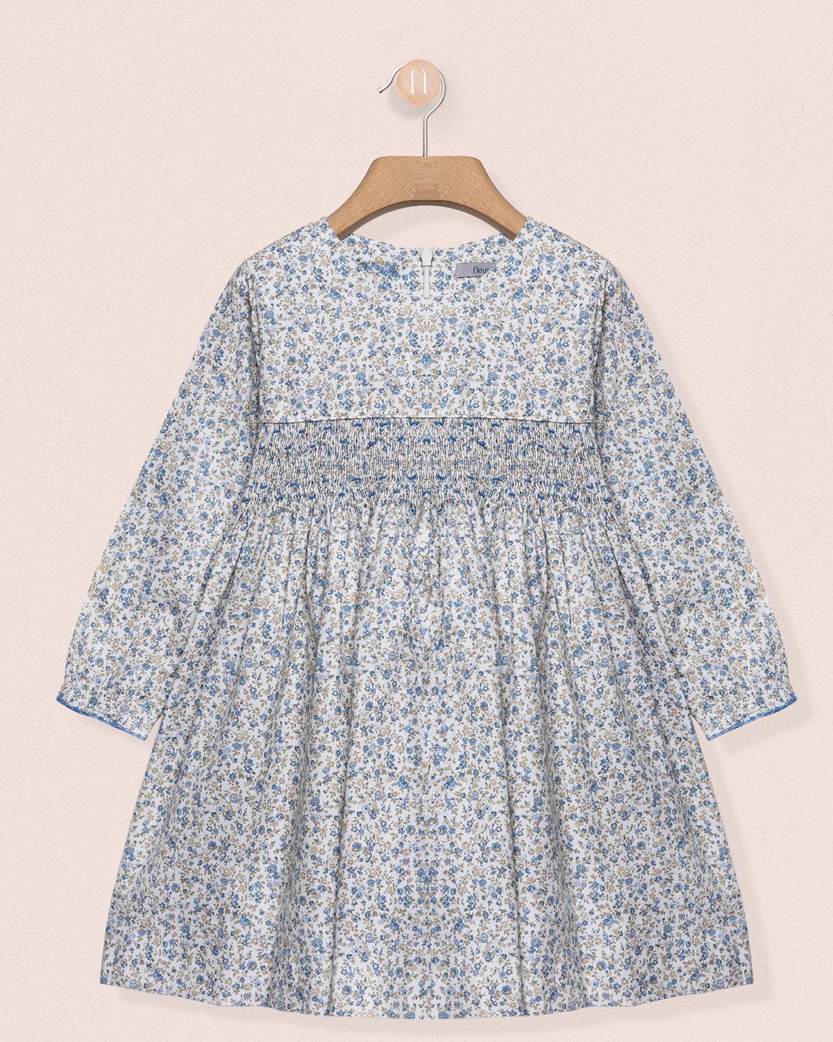 Floral dress on a hanger against a beige background