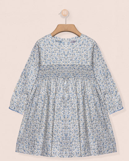 Floral dress on a hanger against a beige background