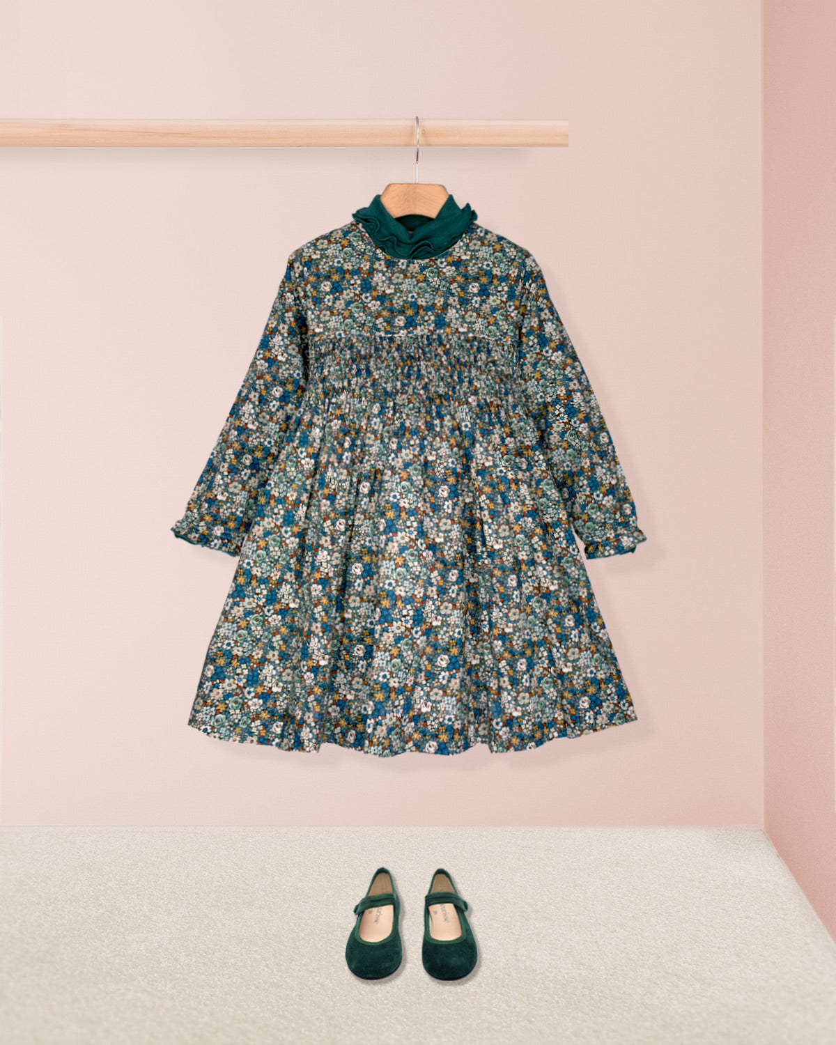 Floral dress with long sleeves and a matching pair of shoes on a pink background
