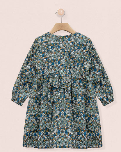 Floral dress on a hanger against a light pink background