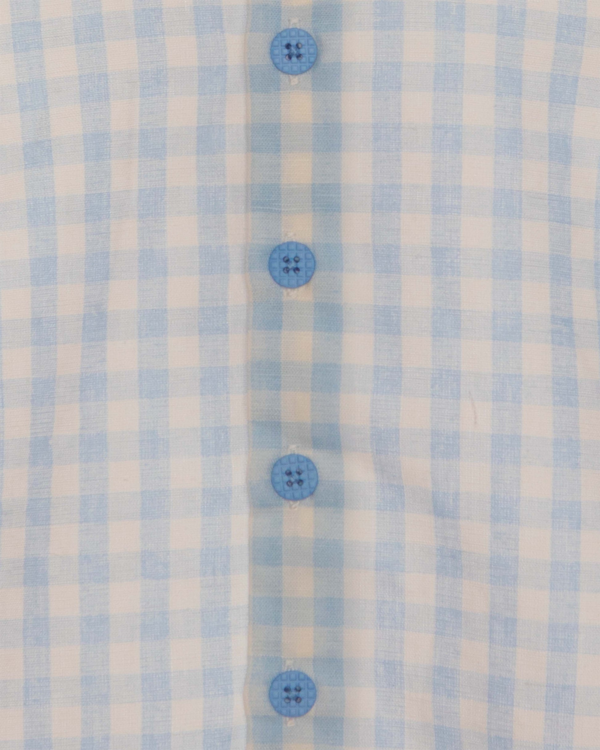 Closeup of light blue and white checkered shirt and blue buttons.