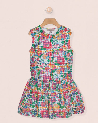 Colorful floral dress on a hanger against a beige background