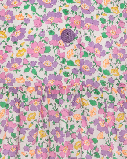 Close-up of floral patterned fabric with colorful flowers and purple button