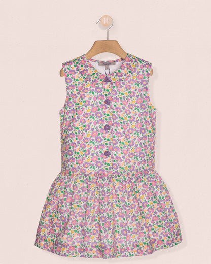 Floral dress on a hanger against a light pink background