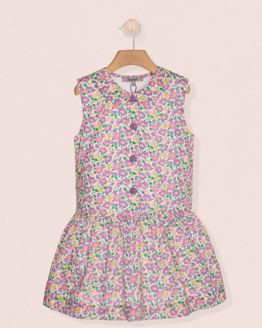 Floral dress on a hanger against a light pink background