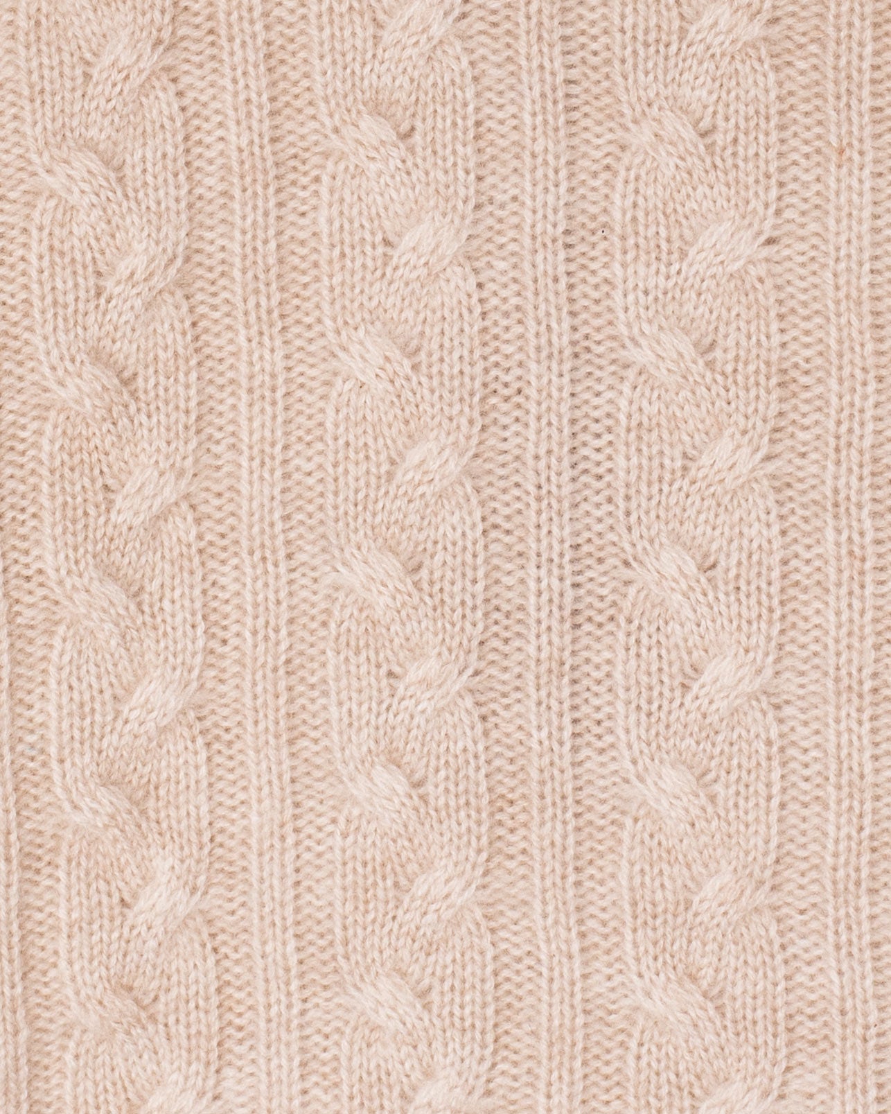Close-up of a beige knitted fabric with cable pattern