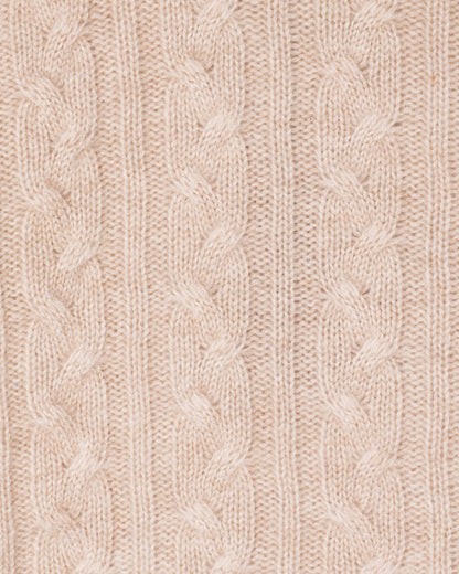 Close-up of a beige knitted fabric with cable pattern