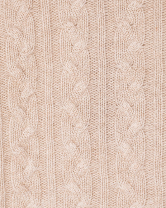 Close-up of a beige knitted fabric with cable pattern