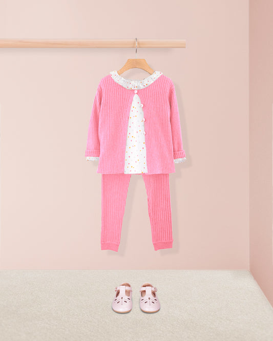 Pink children's outfit with a matching cardigan, top, and pants on a hanger against a pink background.