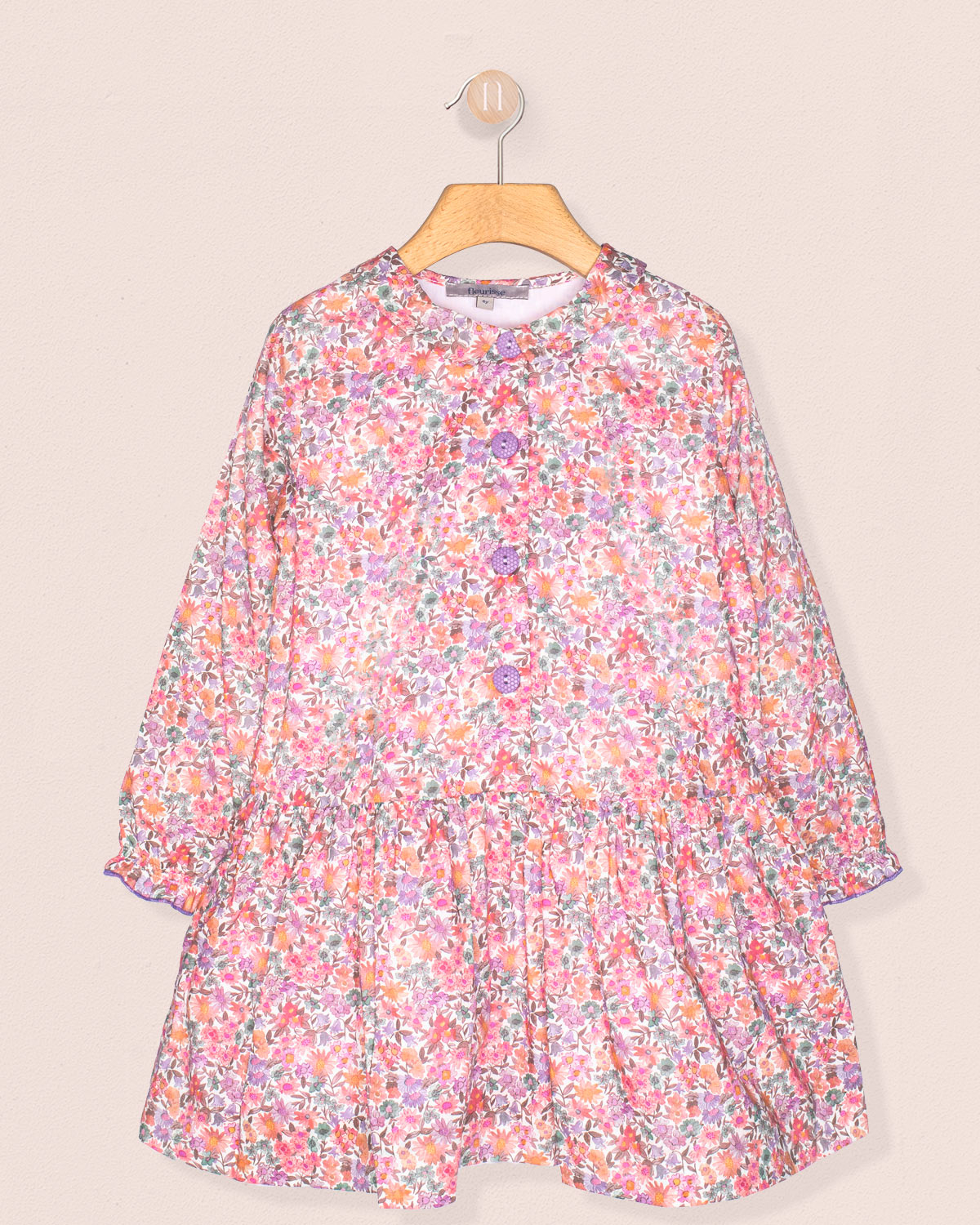 Floral dress on a hanger against a beige background