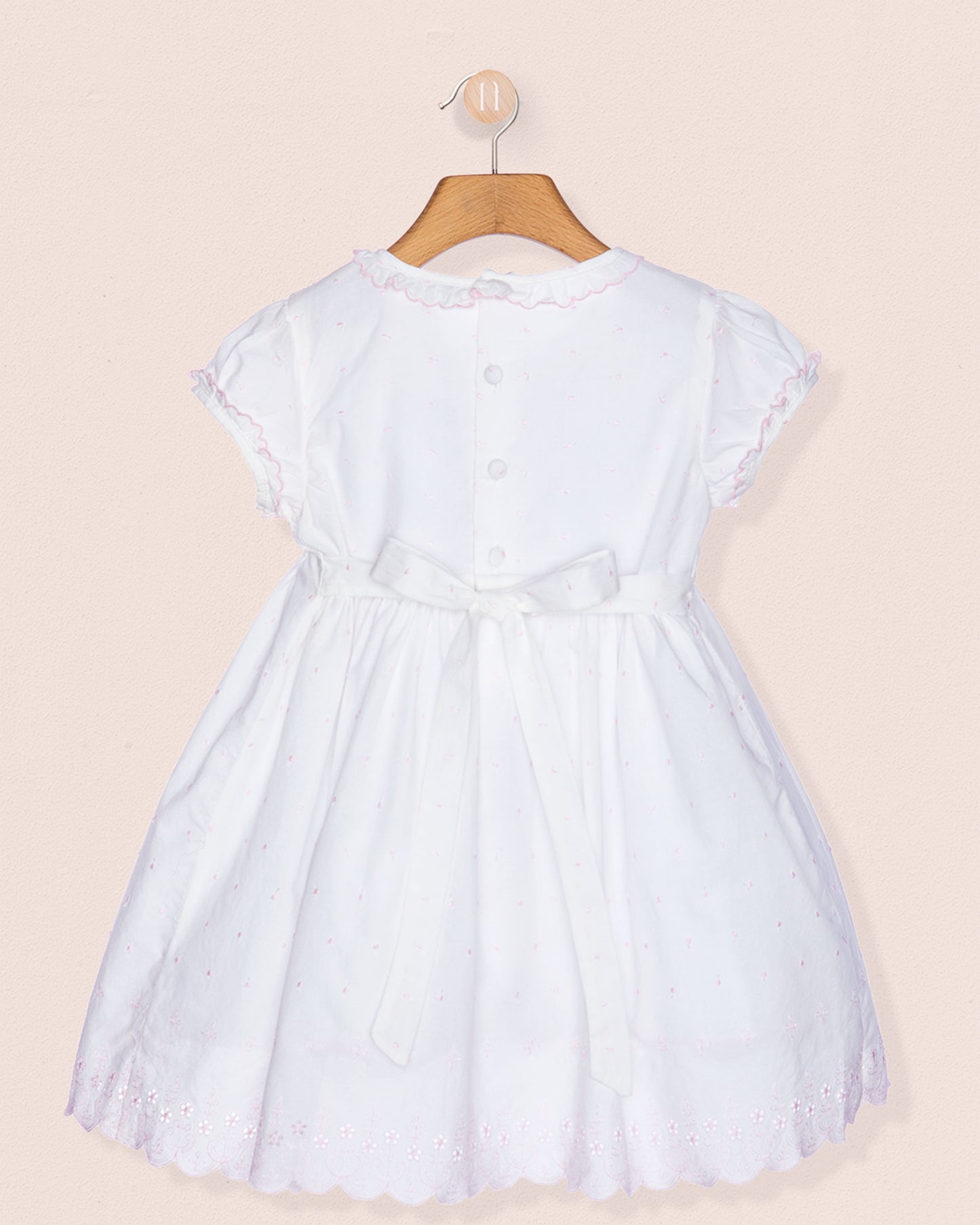 White dress on a hanger against a beige background