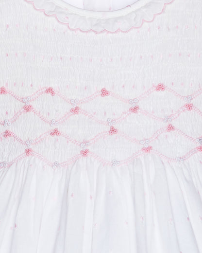 Close-up of a white fabric with pink embroidery patterns