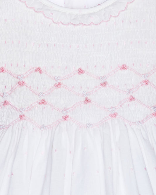 Close-up of a white fabric with pink embroidery patterns