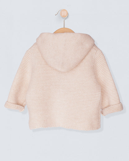 Beige knitted jacket back view on a hanger against a light gray background