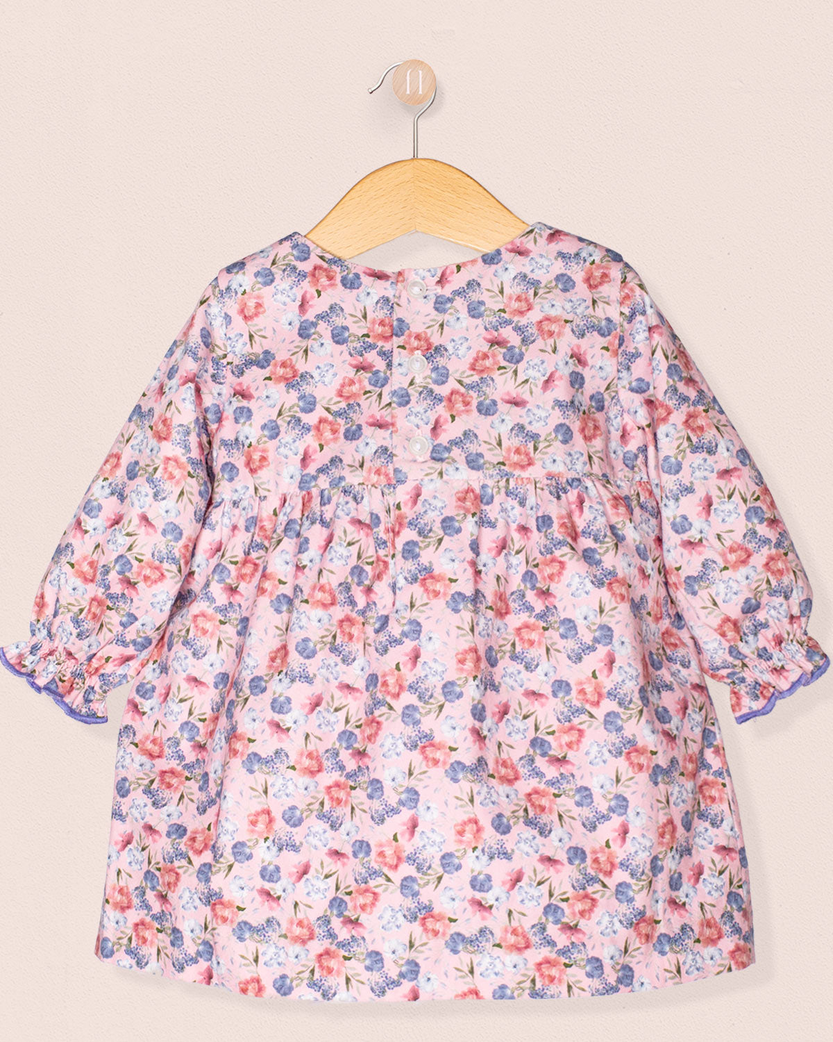 Floral dress on a hanger against a beige background-cack view