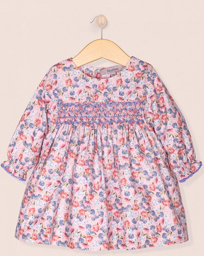 Floral dress on a hanger against a beige background