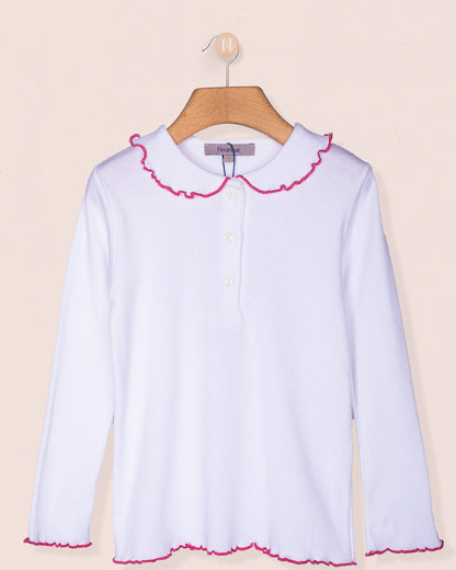 Long sleeve white brushed cotton shirt for girls displayed on a wooden hanger against a pale pink background. Features a rounded ruffle collar and hemline with rose-pink scalloped trim and star-shaped buttons down the front.