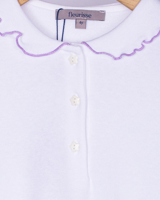 Close-up view of the soft brushed cotton fabric on the white long sleeve shirt, showing the delicate ruffle collar with lavender trim and three small white star-shaped buttons on the front placket.