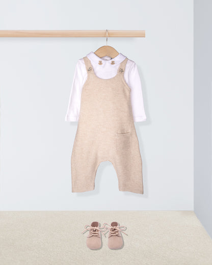 Beige overalls with a white shirt and pink shoes on a light gray background