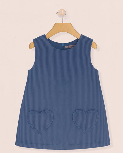 Blue sleeveless dress with heart pockets on a beige background