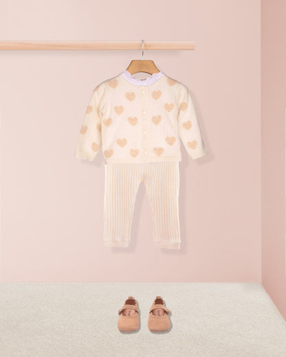 Children's outfit with heart pattern on a pink background