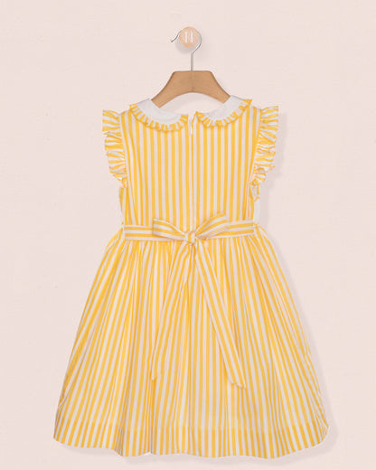 Back of yellow striped dress on a hanger against a beige background