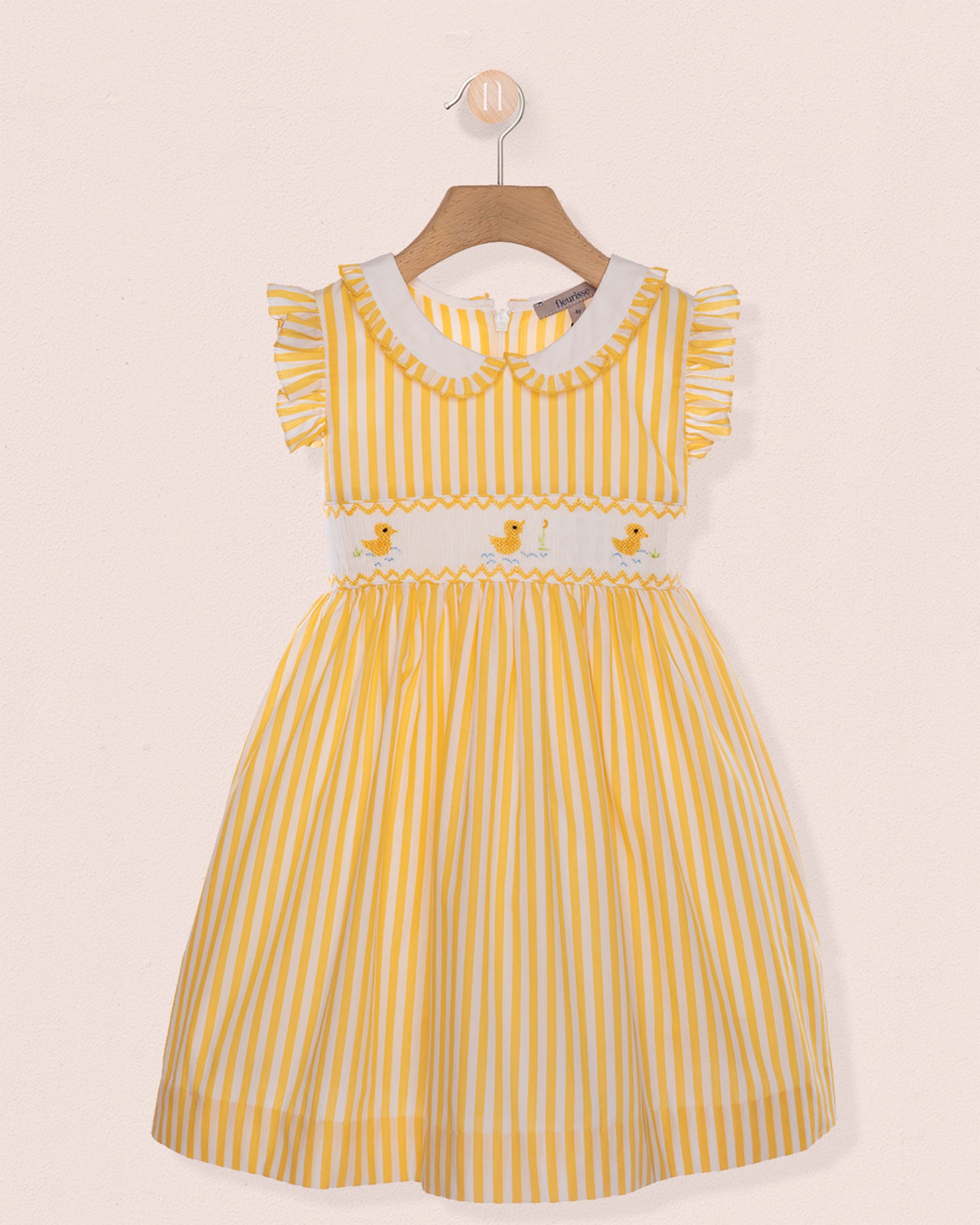 Yellow striped dress with white collar on a beige background