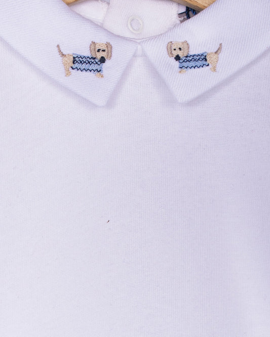 Close-up of embroidered dachshunds wearing blue sweaters on the collar of a white baby onesie made from Italian cotton.