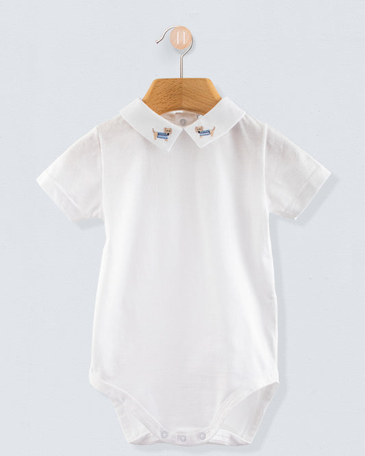 Front view of the Andreas Onesie with Embroidered Light blue Dachshund, a short-sleeve white cotton jersey onesie with a crisp collar featuring embroidered dachshund dogs in light blue sweaters.