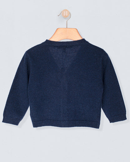 Back of navy blue sweater on a wooden hanger against a light gray background